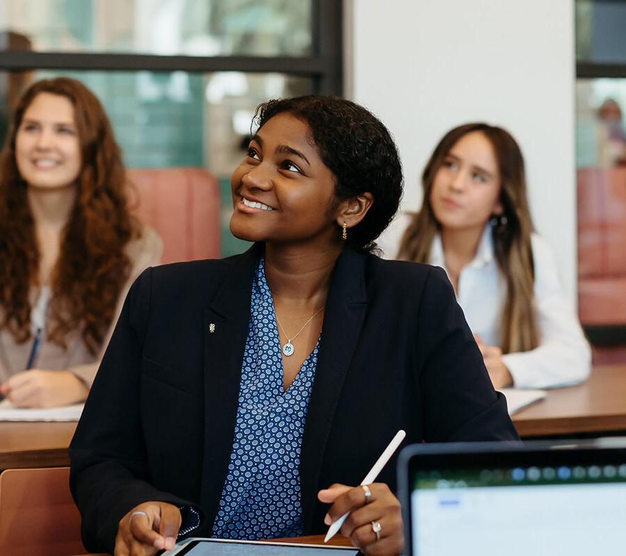 female students smiling and taking notes at Palm Beach Atlantic University